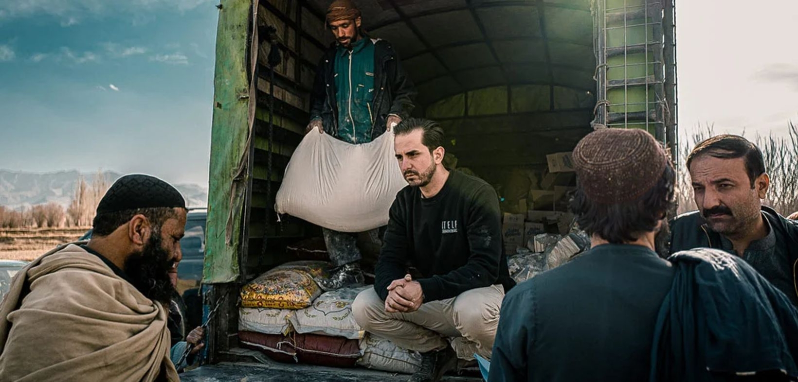 5 Männer beim Ausladen eines LKWs mit Hilfsgütern, in der Mitte Serkan Eren von Stelp e. V.