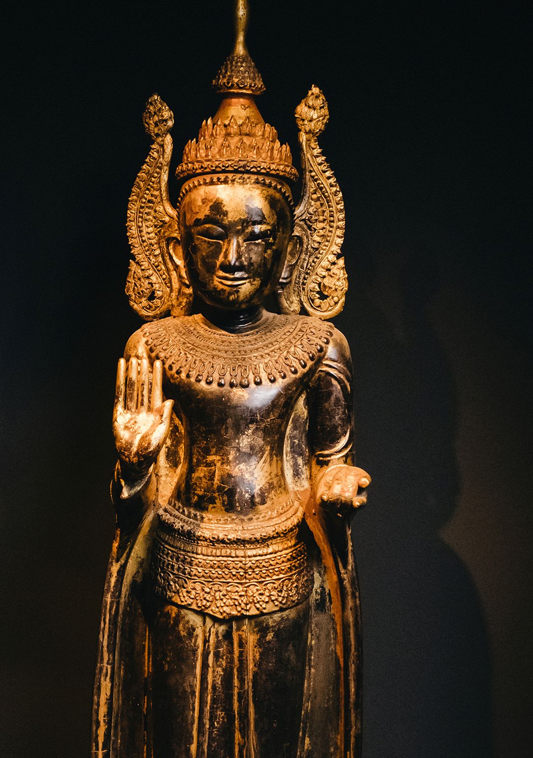 Gekrönter Buddha aus dunklem Holz mit Gold überzogen