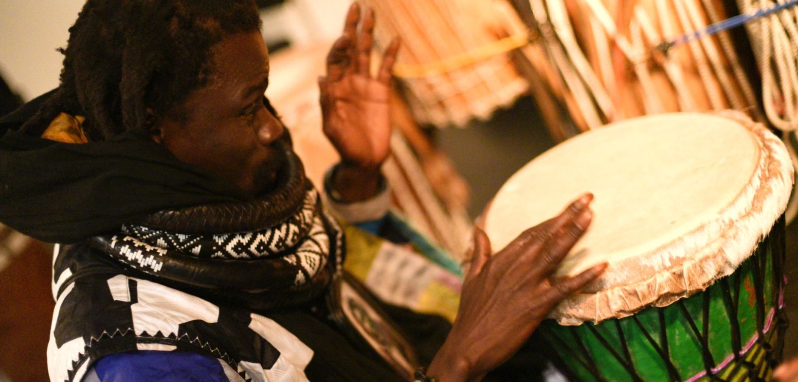 Mame Cheikh Seck, ein junger Schwarzer Mann, trommelt auf der Djembe