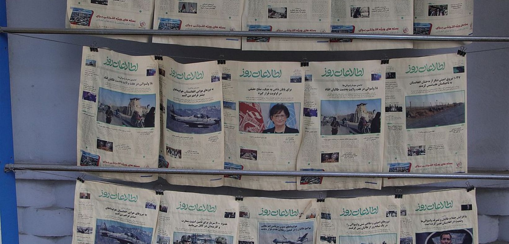 Afghanische Zeitungen hängen in Fünferreihen über Metallstangen