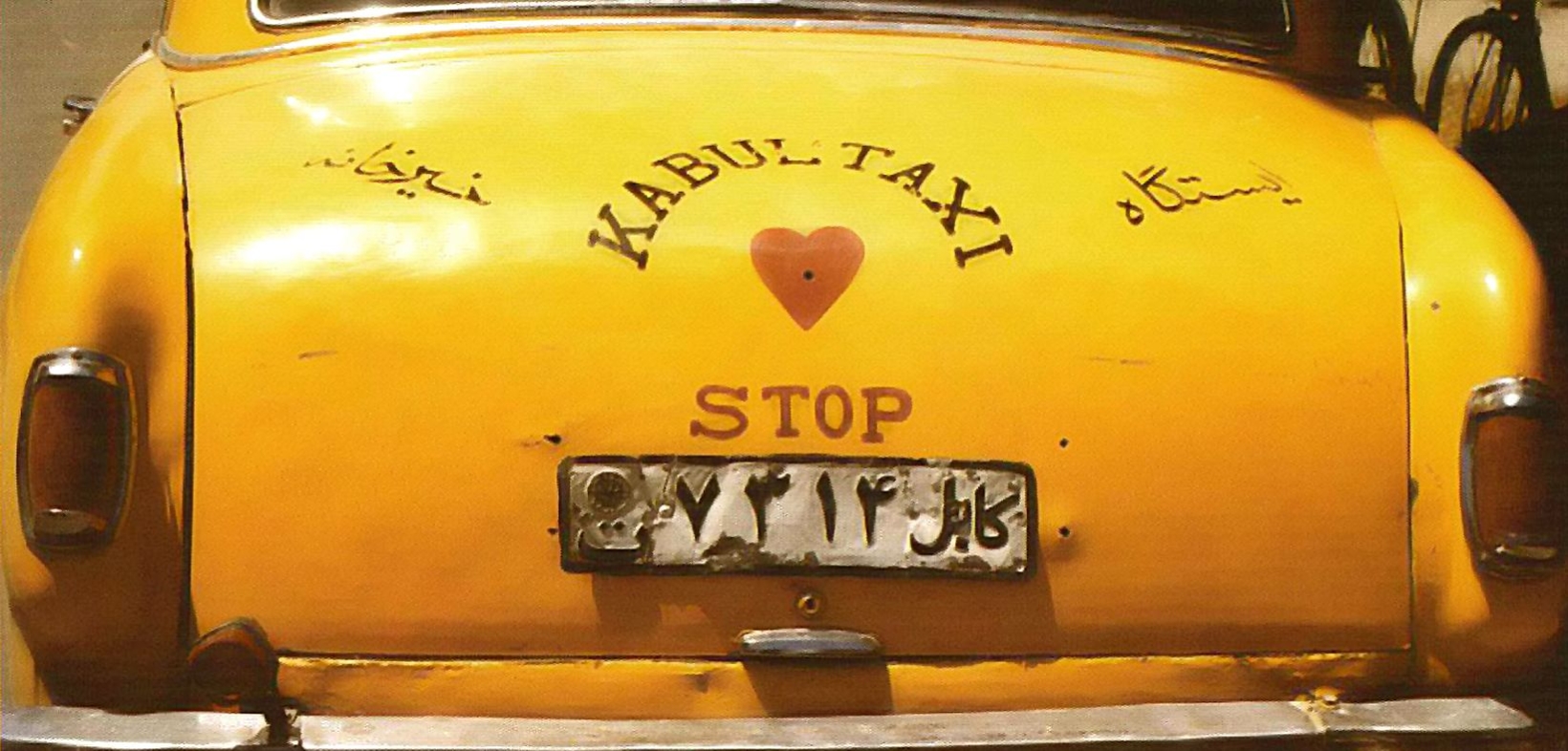 Rückansicht eines gelben Taxis mit der Aufschrift "Kabul-Taxi" und "Stop" und einem roten Herz