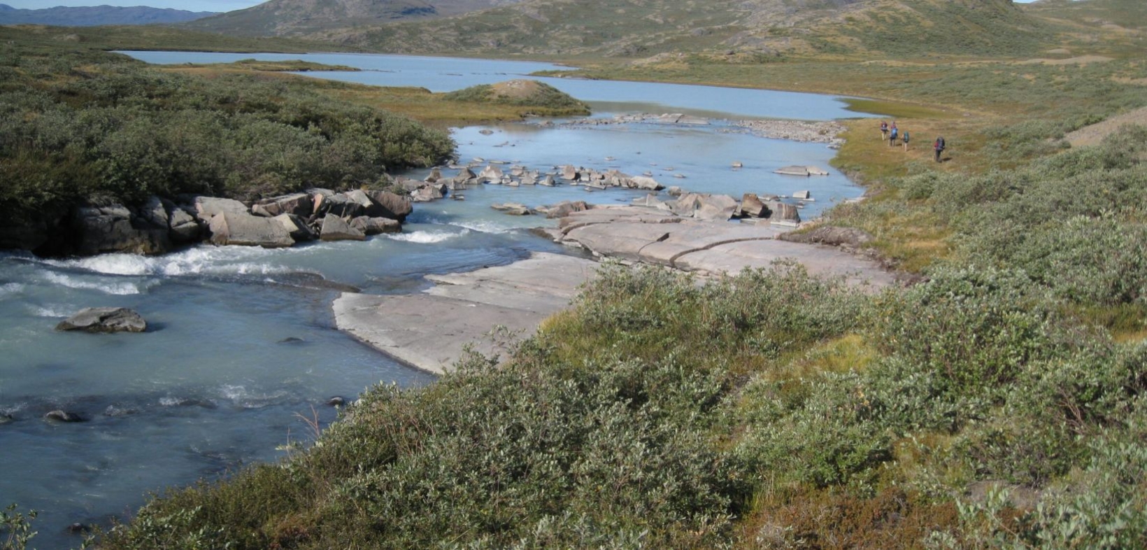 Nördliche Flusslandschaft, ganz klein eine Gruppe Wanderer in der Landschaft