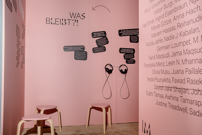 Präsentation von LAB 8: an rosafarbenen Wänden stehen die Frage "Was bleibt?" und die Namen der Beteiligten an den verschiedenen LindenLABs. Zwei Kopfhörer hängen an der Wand, davor stehen drei Hocker.